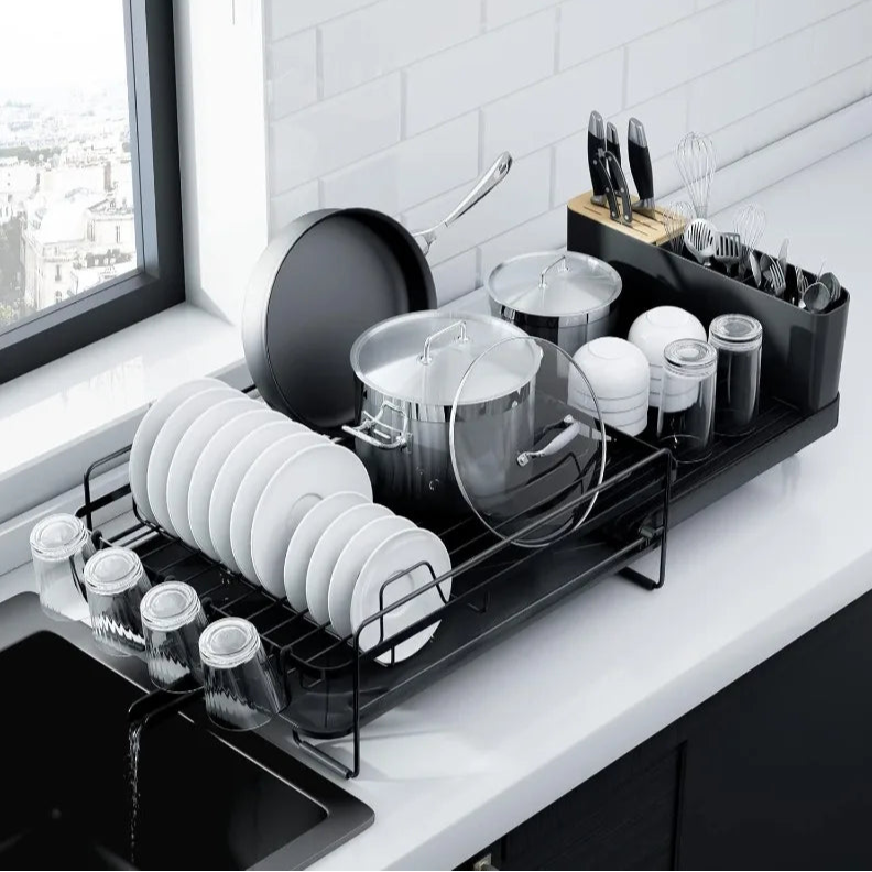 Dish rack with dishes on a kitchen counter near a window