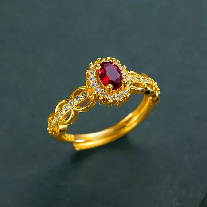 Gold ring with a red gemstone on a dark background