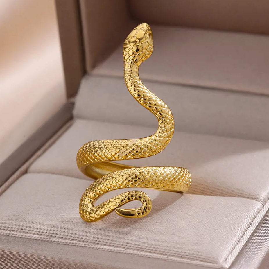 Gold snake-shaped ring on a soft surface