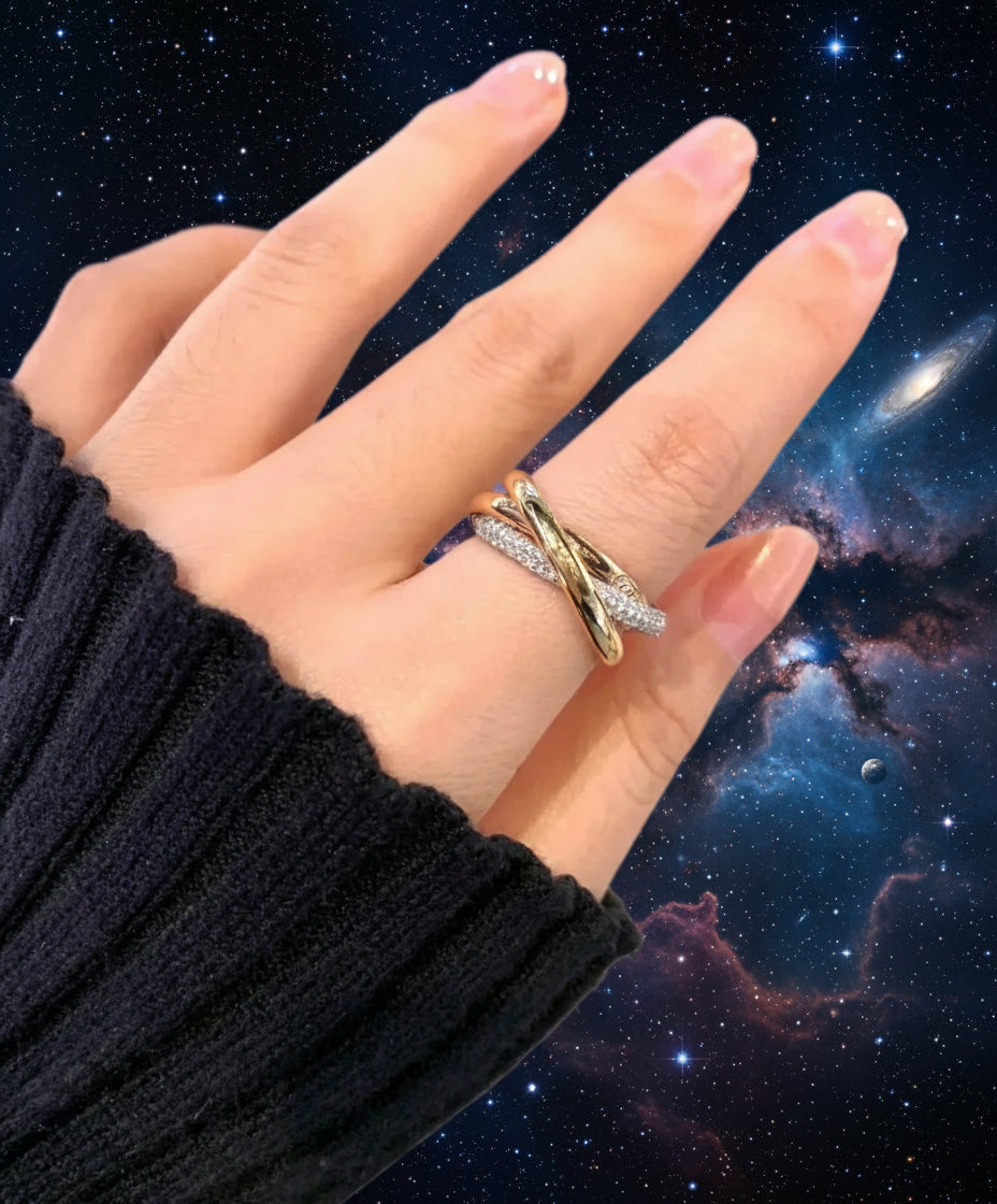 Hand wearing a gold ring with a blurred background
