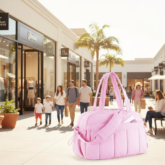 Pink handbag with a shoulder strap on a white background