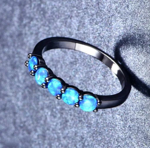 Ring with blue gemstones on a gray background