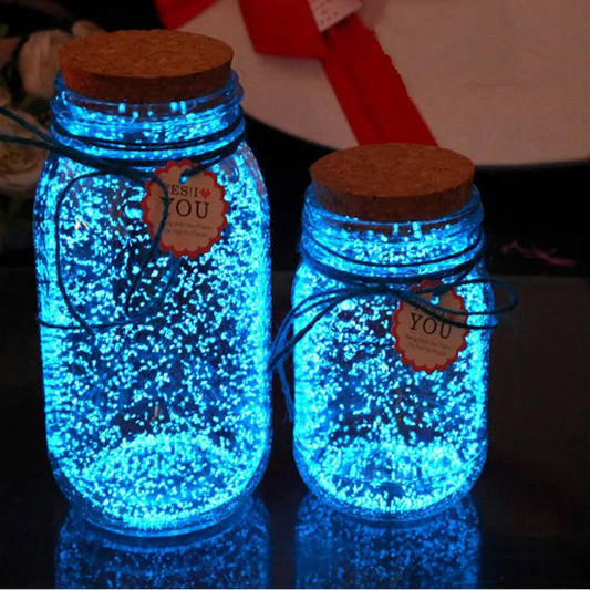 Two glowing blue jars with cork lids on a dark surface.